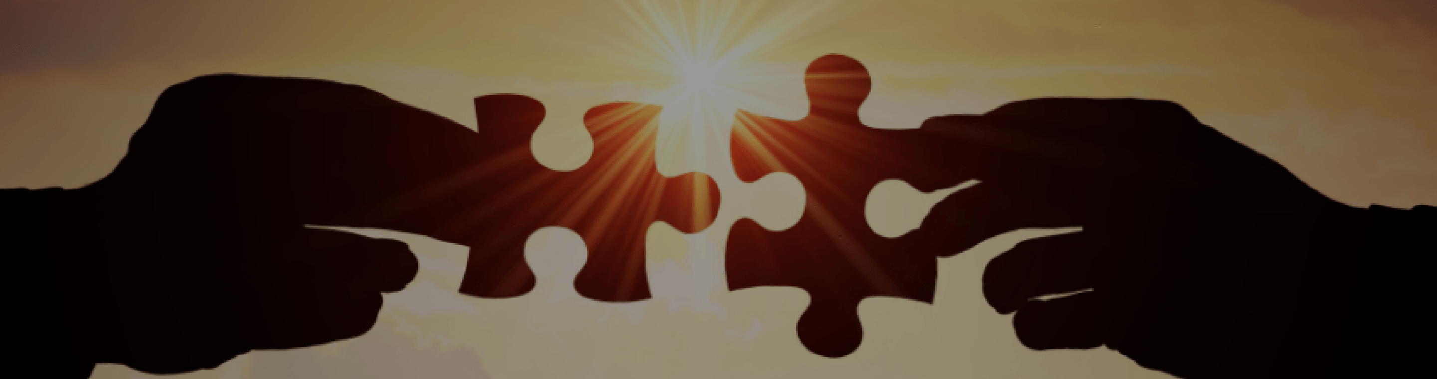 Two hands holding puzzle pieces