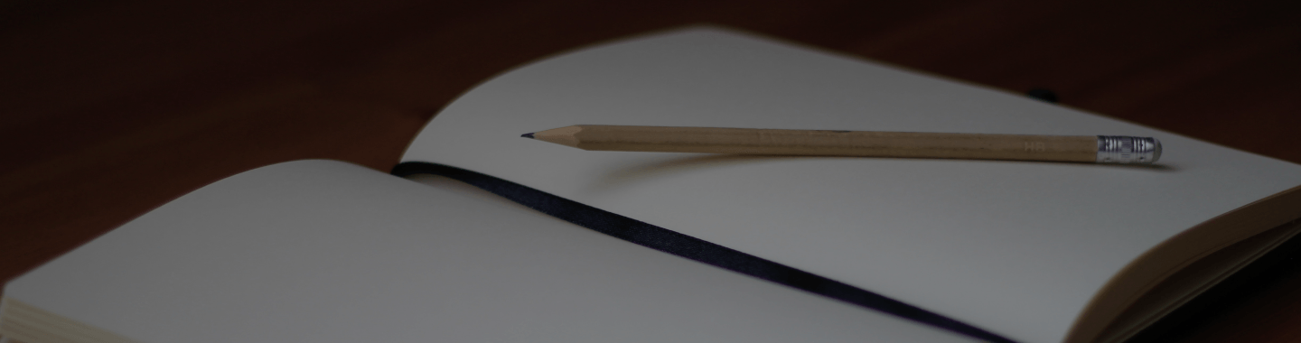 A notebook with a pencil on top